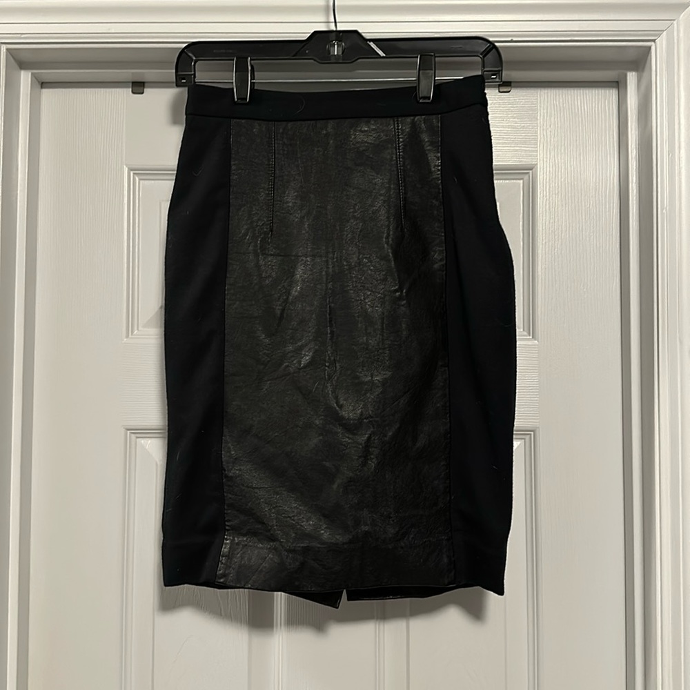 Black high waisted pencil skirt with pleather panels and back slit.